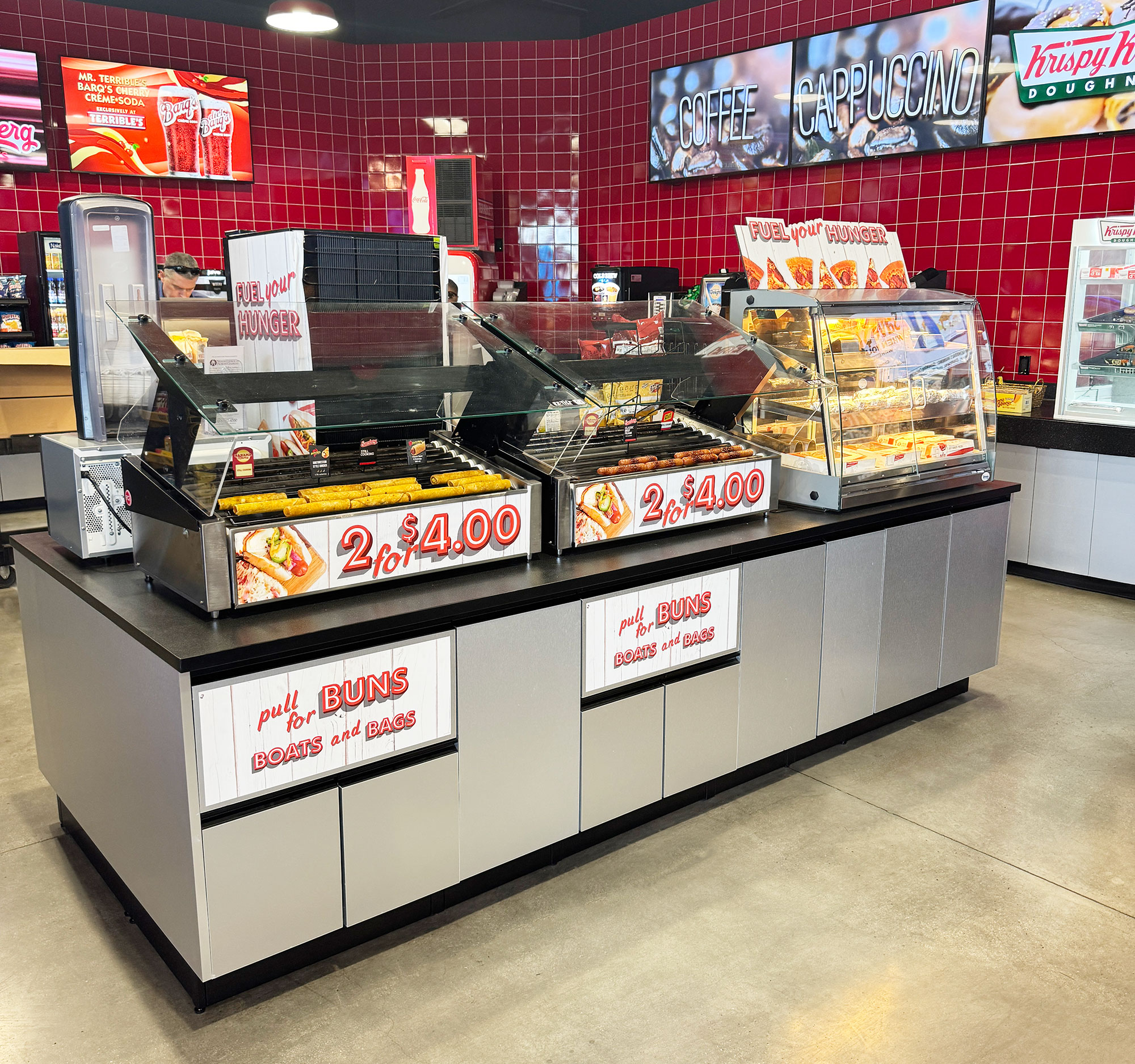 Convenience store foodservice destination featuring commercial roller grills, coffee, and grab-and-go offerings