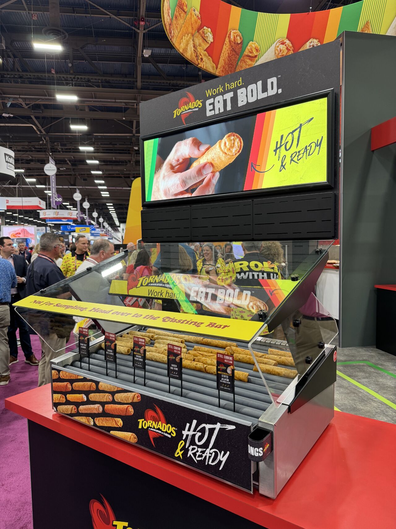 Commercial roller grill display featuring assorted hot foods and merchandising signage